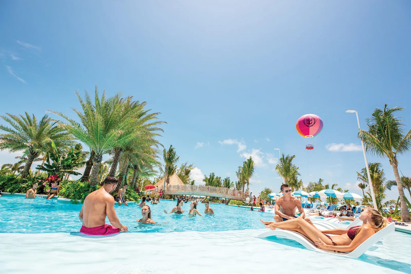 Guests swimming in Oasis Lagoon at CocoCay with the balloon overhead