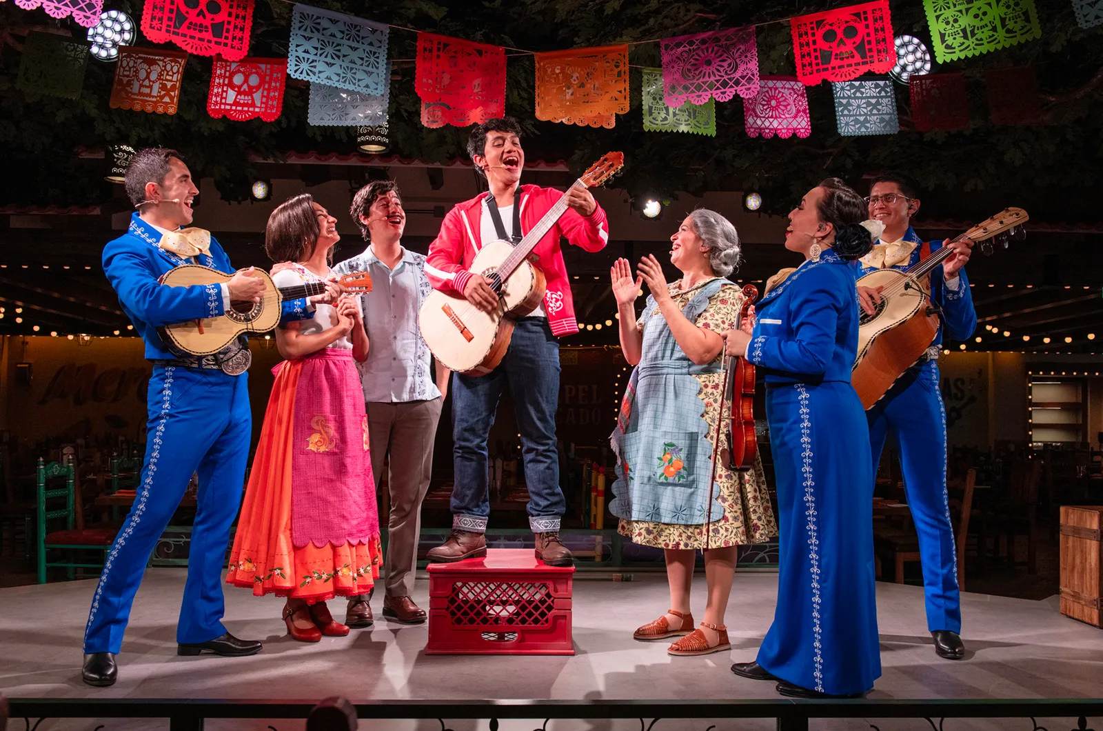 Miguel and mariachi performers on stage at Plaza de Coco